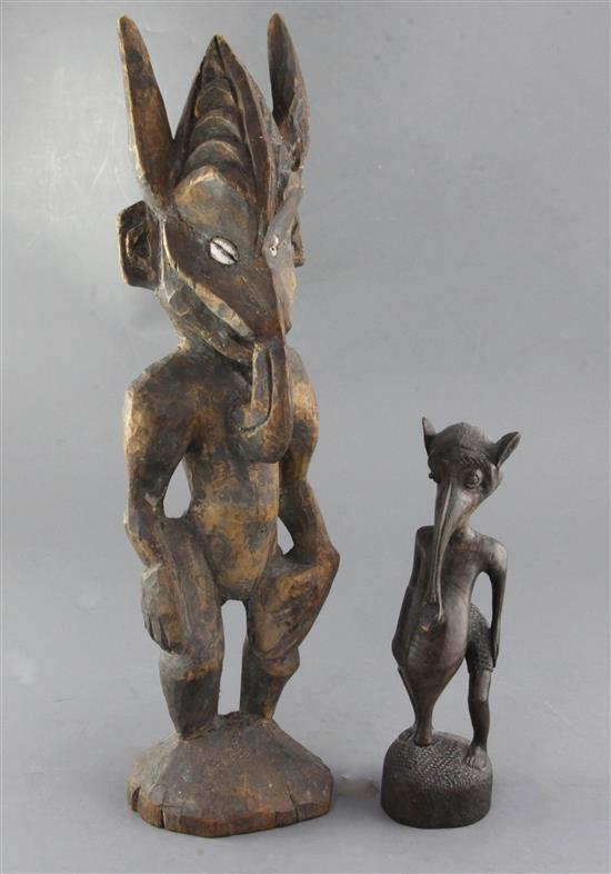 A Lower Sepik carved wood ancestral figure, with cowrie inset eyes, 40cm and a similar smaller figure, 23cm